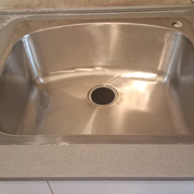 כיור נירוסטה מותקן על משטח עבודה במטבח