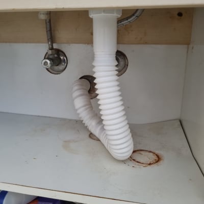 צינור פלסטיק מתחת לכיור עם חיבורים