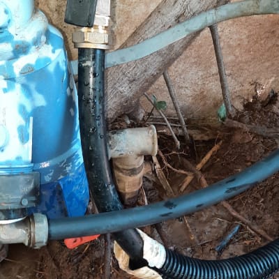 צינור מים עם חיבורים ושסתום באזור לח ומלוכלך