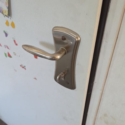 ידית דלת מתכת על דלת לבנה