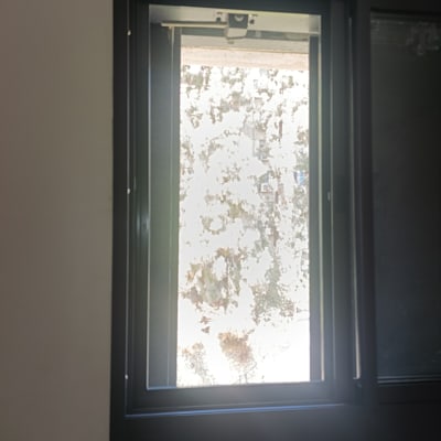 חלון אלומיניום עם נוף חיצוני מטושטש