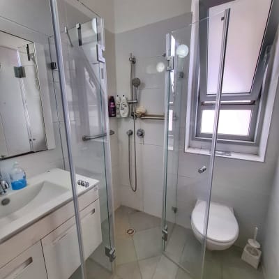 מקלחון זכוכית עם ראש מקלחת ומוצרי רחצה