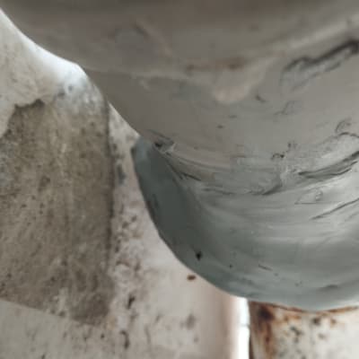 צינור מתכת עם תיקון בעזרת חומר איטום אפור