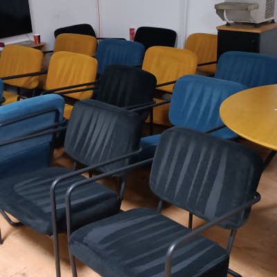 כיסאות מרופדים בצבעים שונים בחדר ישיבות