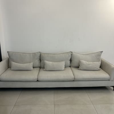 ספה אפורה עם כריות על רצפת אריחים