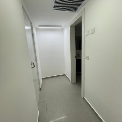 מסדרון עם קירות לבנים צבועים ותקרה לבנה