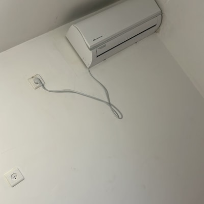 מזגן מותקן על קיר עם כבל חשמל מחובר