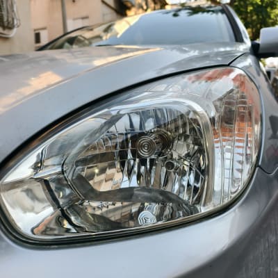 פנס קדמי של רכב עם השתקפות בניינים