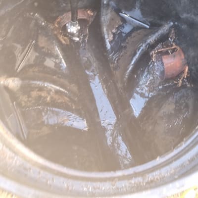 צינור שחור בתוך מיכל עם נוזלים כהים