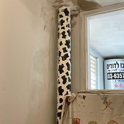 קיר עם תיקוני צבע וגליל נייר עטוף בדוגמת פרה