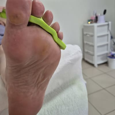 כף רגל עם מפריד אצבעות ירוק בטיפול פדיקור