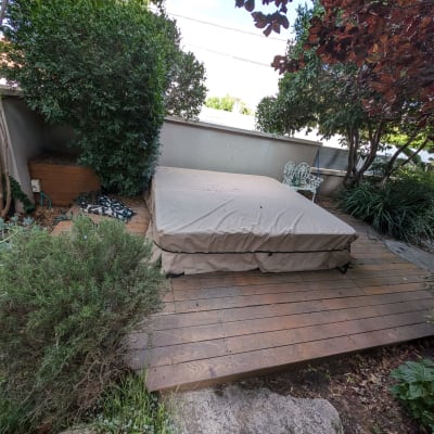 wooden deck with covered hot tub and garden plants