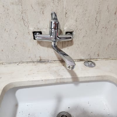 ברז מותקן על קיר מעל כיור לבן