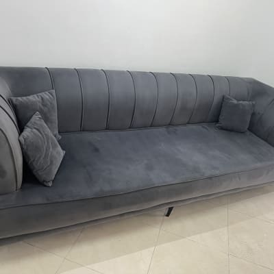 ספה אפורה עם כריות על רצפת אריחים