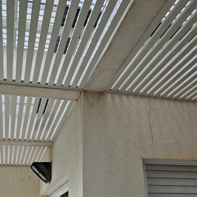 פרגולה עם קורות עץ לבנות בגינה