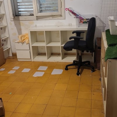 חדר עם מדפים, כיסא משרדי ורצפת אריחים צהובה