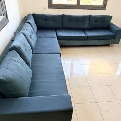 ספה כחולה גדולה בחדר עם רצפת אריחים