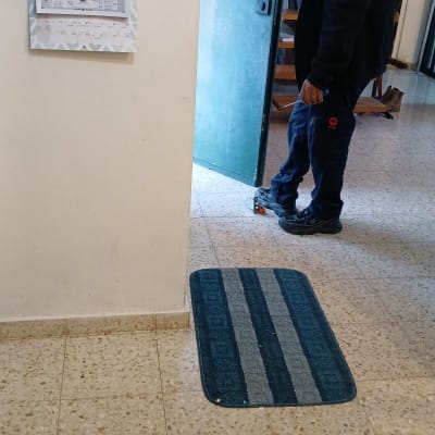 אדם עומד ליד דלת עם כלי עבודה