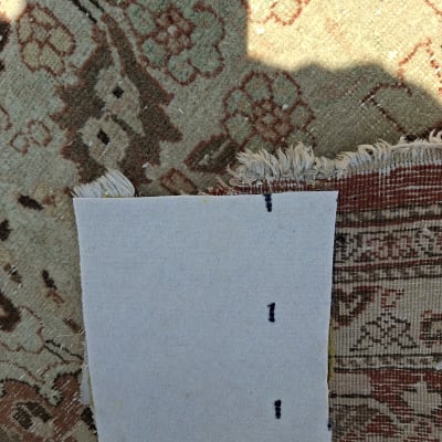 שטיח עם דוגמה וחתיכת נייר לבנה