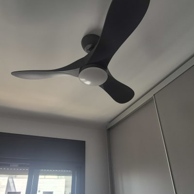 מאוורר תקרה שחור בחדר עם חלון גדול