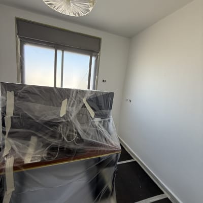 חדר עם רהיטים מכוסים בניילון לקראת צביעה