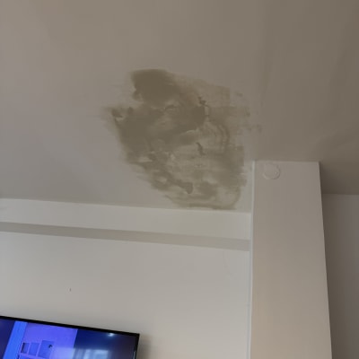 תקרה עם סימני תיקון צבע ליד טלוויזיה