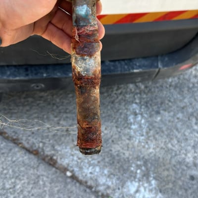 יד מחזיקה צינור חלוד עם חוטים