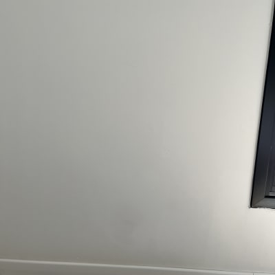 קיר צבוע עם מסגרת חלון ורצפת עץ