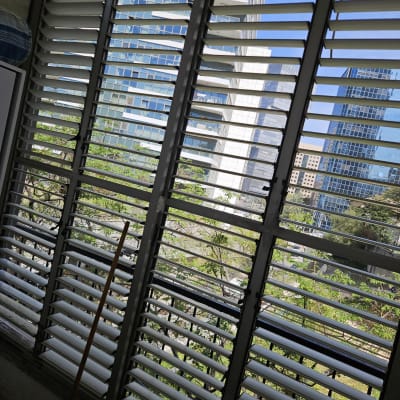 תריסים אופקיים פתוחים עם נוף עירוני ברקע