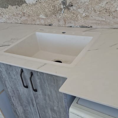 משטח שיש עם כיור מובנה ומכונת כביסה