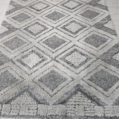 שטיח אפור עם דוגמאות גיאומטריות על רצפה בהירה