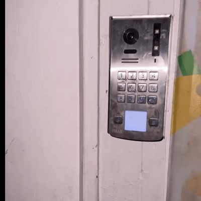 מערכת אינטרקום עם לוח מקשים על קיר לבן