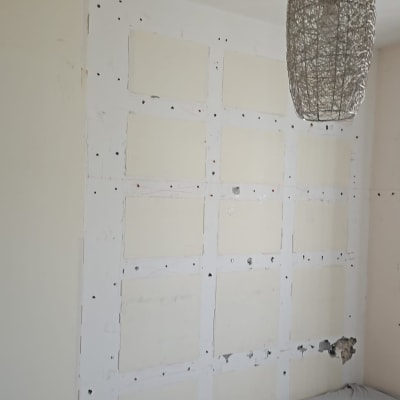 קיר עם תיקוני גבס ומנורה תלויה