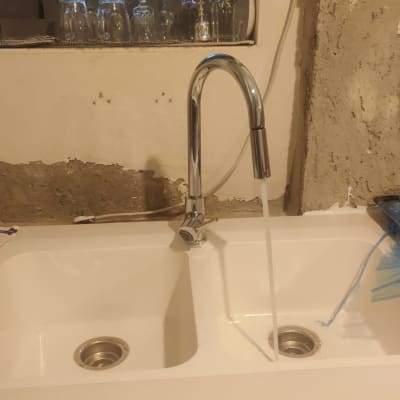ברז מים זורם בכיור כפול עם קיר חשוף