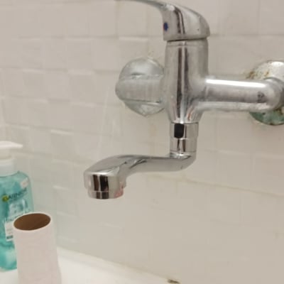 ברז כרום מותקן על קיר עם אריחים לבנים