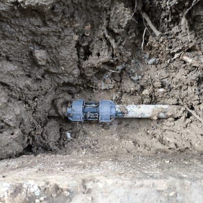 צינור מים עם מחבר פלסטיק באדמה רטובה