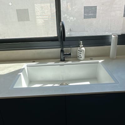 כיור מטבח עם ברז וסבון נוזלי על השיש