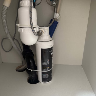 צנרת מתחת לכיור עם מסנן מים ומחברים