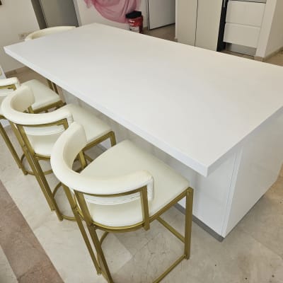 דלפק מטבח לבן עם כיסאות בר לבנים