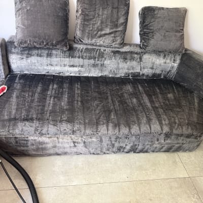 ספה אפורה עם כלי ניקוי מונח עליה