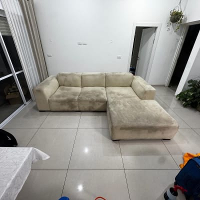 ספה בהירה עם כתמים על הרצפה