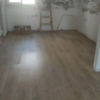 רצפת פרקט עץ בחדר ריק עם סולם קיר.