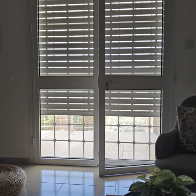 תריסי אלומיניום פתוחים על דלת זכוכית