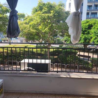 מעקה ברזל שחור עם וילונות קשורים בצדדים