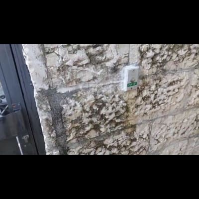 אינטרקום מותקן על קיר אבן חיצוני