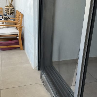 רשת קרועה על דלת הזזה במרפסת