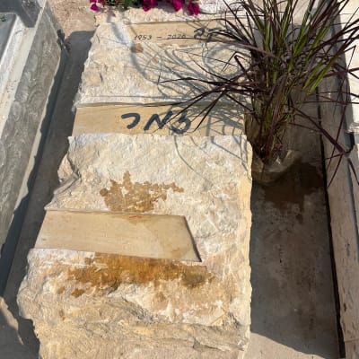 מצבה עם פרחים ואבן גדולה