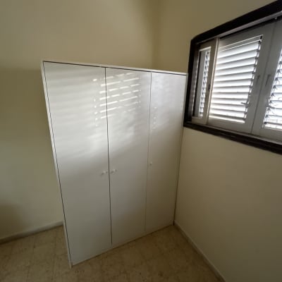 ארון לבן ליד חלון עם תריסים