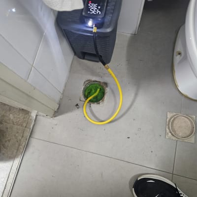 מכשיר בדיקה עם כבל צהוב ליד פתח ניקוז