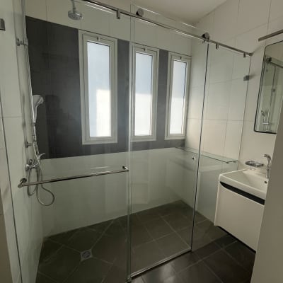 מקלחון זכוכית עם ראש מקלחת וכיור בחדר אמבטיה מודרני